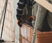 bricklayer-installing-brick-masonry-on-interior-wa-HT2PJM3